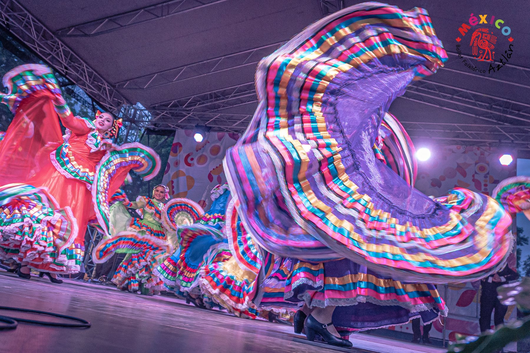 Aztlán dancers mid-spin in full folklórico skirts